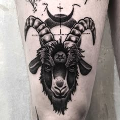 a goat tattoo on the leg with cross and moon above it's head in black ink