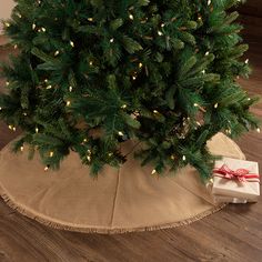 a small christmas tree with lights on it and a present wrapped in burlock