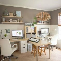 a home office with two computer desks and shelves