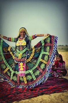 a woman in an elaborately designed dress poses for the camera