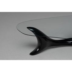 an oval glass table with black curved legs