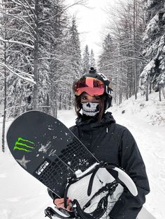 a man holding a snowboard while standing in the snow