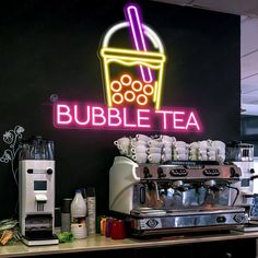 a neon sign that says bubble tea on the side of a coffee shop with various drinks