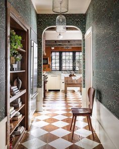 a chair sitting in the middle of a hallway next to a kitchen and dining room