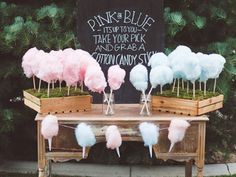 a table with cotton candy on it and a sign in the background that says gender reveal