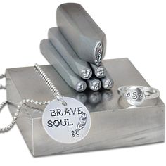 a metal box with some silver items on it and a tag that says brave soul