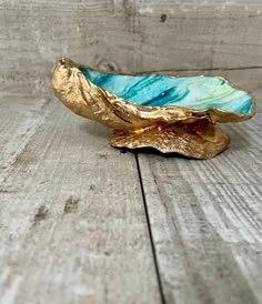 a blue and gold bowl sitting on top of a wooden table