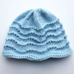 a blue knitted hat sitting on top of a white table