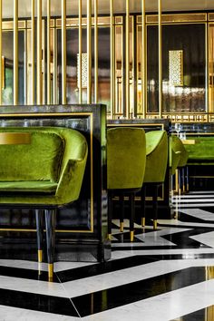 the interior of a restaurant with green chairs and black and white checkered flooring