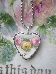 a heart shaped necklace with roses painted on it