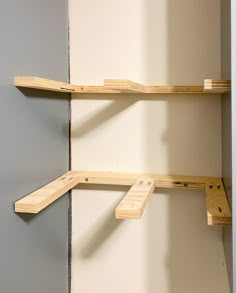 two wooden shelves are attached to the wall