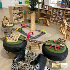 an assortment of toys and furniture in a playroom with zebra print rugs on the floor