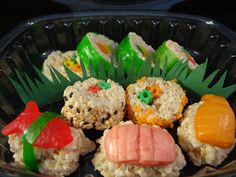 there are many sushi on the plate in this plastic container, and one is made out of rice krispy kreme