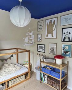 a child's bedroom decorated in white and blue with pictures on the wall above it