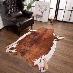 a cowhide rug in the middle of a living room with a chair and deer