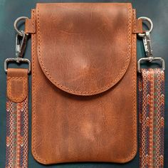 a brown leather pouch with two straps