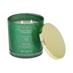 a green candle with a gold lid