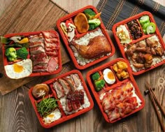 four red trays filled with different types of food on top of a wooden table