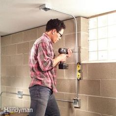 a man is using a drill to fix a wall