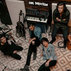 a group of young men sitting next to each other in front of musical instruments and keyboards