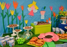 a table topped with cakes and desserts next to green boxes filled with candies