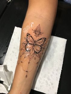 a woman's leg with a butterfly tattoo on the left side of her arm