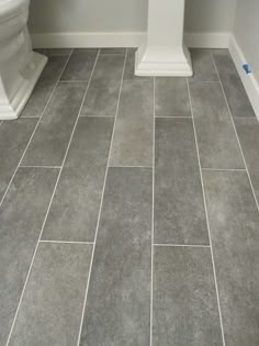 a white toilet sitting next to a bath tub in a bathroom on top of a tiled floor