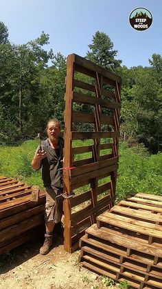 a man standing next to some wooden pallets