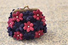 a small purse with red, white and blue crocheted flowers