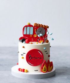 a red and white cake with a firetruck on it's tiers