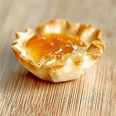 a close up of a pie on a wooden table with honey in the crusts