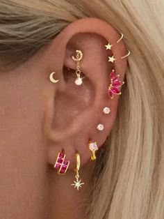 a woman's ear with five different colored stones and stars on the top of it