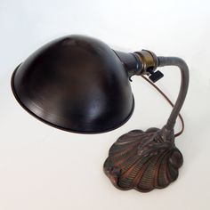 a desk lamp sitting on top of a white table next to a leaf shaped object