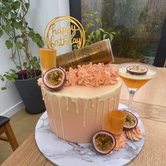 a birthday cake on a table with some fruit and champagne in front of the cake