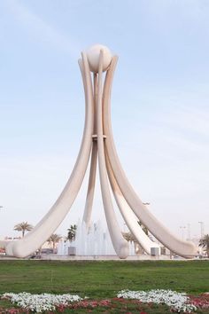 a large sculpture in the middle of a park with water spouting from it's sides