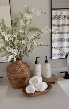 a bathroom with white flowers in a basket and soap dispensers on the counter