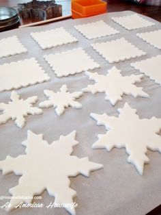 snowflake cookies on a baking sheet ready to be cut and decorated for christmas