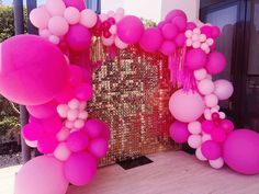 pink and white balloons are on display at a party