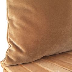 a brown pillow sitting on top of a wooden bench