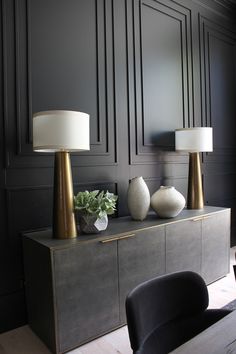 two lamps sitting on top of a dresser in a room