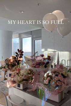 flowers and balloons are sitting on the counter in front of a mirror that says, my heart is so full