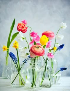 several glass vases with flowers in them on a table