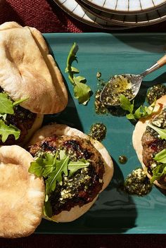 three pita sandwiches on a blue plate with broccoli