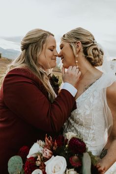 the bride and her mother share a tender moment before their wedding ceremony on top of a mountain