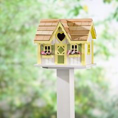 a bird house on top of a white pole