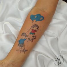 a person with a tattoo on their arm holding onto a blue balloon that says happy