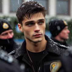 a man in black jacket standing next to other men wearing police hats and jackets on the street