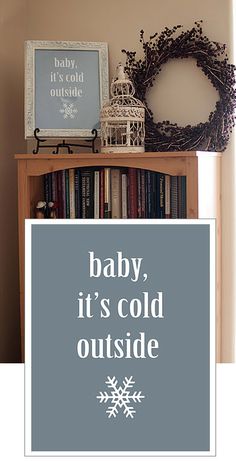 a baby, it's cold outside sign next to a bookshelf