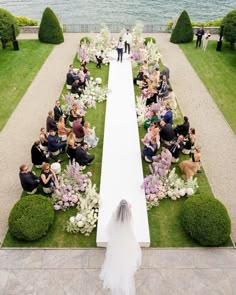 a bride and groom walking down the aisle to their wedding ceremony in an elegant garden