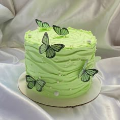 a cake with green frosting and butterflies on it